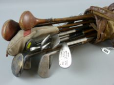 A canvas bag of old golf clubs including irons, bearing the name 'TW (Tom) Jones, Maesdu,