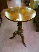 An early Victorian circular mahogany tripod coffee table having a well shaped turned and tapered