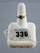 An eighteen carat gold crossover dress ring having a centre sapphire and flanking diamonds (two) and