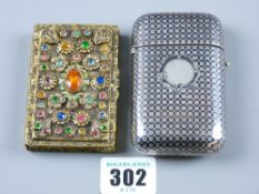 A shallow yellow metal lidded case, the lid encrusted with precious stones as flowers and a white