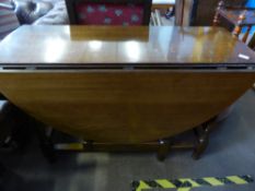 An oval oak drop leaf dining table on part turned legs, est. 135 x 113 x 75 cms.