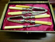 A cased set of butter and cheese knives and two forks, all with silver handles together with a cased