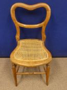 A vintage child's cane back chair having a leather seat together with a small cane seated balloon