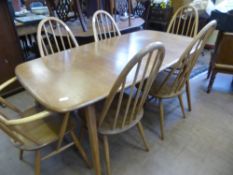 A light oak Ercol dining table together with a matching set of eight dining chairs including two