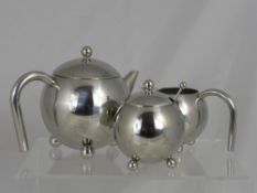 A Contemporary Art Deco Stainless Steel Tea Trio, comprising teapot, milk jug and sugar bowl.