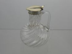 A Silver Topped Glass Water Jug, the jug having a thumb rest to the lid, Birmingham hallmark, m.m JG