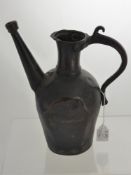 An Antique Bronze Ewer, with curved handle with decorative scroll and a straight spout, possibly
