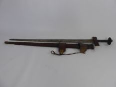 An Antique North African Sword, having a leather covered grip and quillion with tooled and decorated
