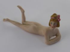 An Edwardian Bisque Bathing Belle, depicted lying down.