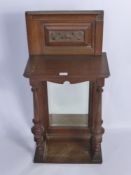 An Arts and Crafts Hall mirror with turned supports.