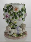 A Circa 1900 Dresden Style Putti Vase, the vase decorated with roses having three putti to beaded