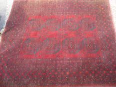 An Afghan Rug, having eight medallions to the central panel with geometric border.