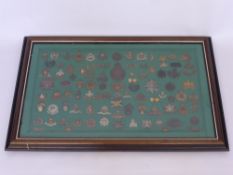 A Framed Display of Military Badges, approx 100 items, including Royal Flying Corps, Manchester Reg.