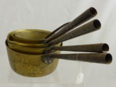 A Set Of Five Brass Graduated Fireside Saucepans.
