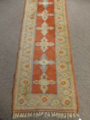 A Middle Eastern Woollen Hall Runner, of geometric design with orange ground and blue and cream
