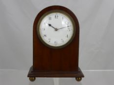 An Edwardian French Mahogany Mantel Clock, the clock having white enamel face on ball feet.