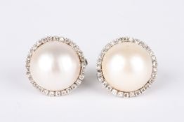 A large pair of diamond and pearl earrings, each set with a large pearl and surrounded by 29 small