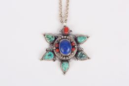 A star shaped coral, turquoise, lapiz lazuli and white metal pendant the outer section of the