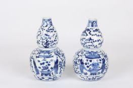 A pair of Chinese blue and white double gourd vases and covers, late 19th / early 20th century,