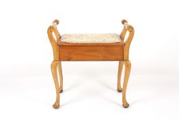 An Edwardian piano stool, with scrolled arms, padded rising seat and supported on cabriole legs,