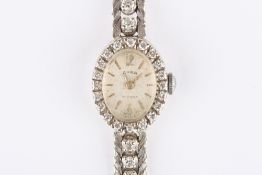 An Art Deco Cara 18ct gold and diamond ladies cocktail watch, the oval silvered dial with baton