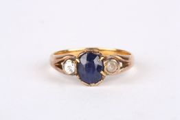 An 18ct gold, sapphire and diamond ring, set with oval sapphire flanked either side by a diamond