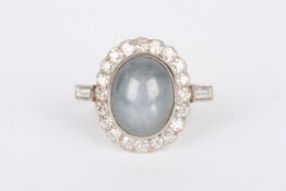 An Art Deco platinum, diamond and star sapphire cluster ring set with large oval star sapphire,