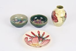 Four pieces of miniature Moorcroftcomprising a Hibiscus vase; a pair of small green ground floral