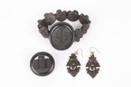 A Victorian carved bog oak suite of jewellerycomprising: a bracelet with carved central oval