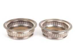 A pair of silver decanter standshallmarked Birmingham 1971, with gadrooned rim and pierced sides