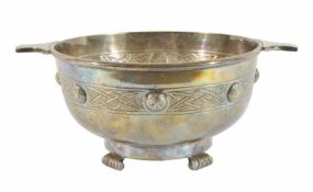 A silver plated quaich with Celtic designed band to the body, raised on four inverted scroll
