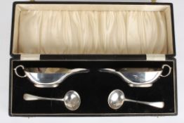 A pair of George V silver sauce boats and ladleshallmarked Birmingham 1937 of plain form with
