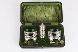 An Edwardian Art Nouveau silver and green glass cruet sethallmarked Birmingham 1906, of pierced and