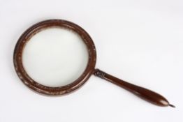 A large Victorian mahogany magnifying glasswith turned handle, 38 cm long.Condition: Split to top