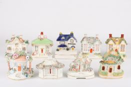 A collection of eight Victorian Staffordshire pottery pastille burner cottagesall with encrusted