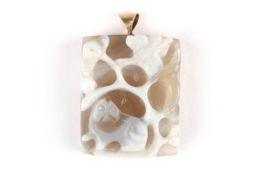 An early 20th century Oriental carved agate pendantdecorated with a man holding a staff and an