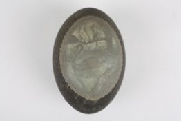 A Victorian carved Emu egg 'While the Billy Boils'decorated with a cameo type scene of a man