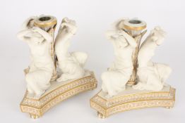 A pair of Victorian Copeland parian three graces candlesticksformed as three kneeling semi-nudes
