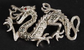 A white metal dragon brooch with inset r