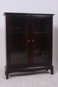 A Stag mahogany minstrel bookcase displa