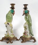 A pair of gilt metal and ceramic parrots