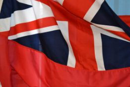 A large British naval flag being hand st