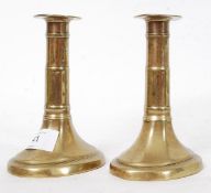 A pair of Georgian pusher brass candlest
