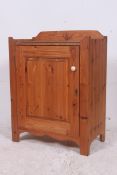A pine 20th century cabinet having central door with gallery top above having inset glass panel.