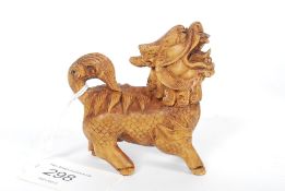 An intricate carved netsuke style temple dog / dragon with inset black eyes.