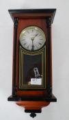 A  20th century Highlands mahogany cased wall clock striking on a gong complete with pendulum and