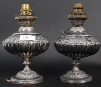 A pair of 19th century silver plate oil lamps having chase decorated detailing being converted to