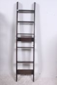 A 1930's Art Deco wall mounted oak display stand having adjustable shelves with angled base and
