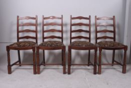 A set of 4 mid 20th century ladderback dining chairs with tapestry drop in seats and wavey ladder