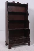 A large mahogany antique style waterfall bookcase having drawers above the plinth base with shaped